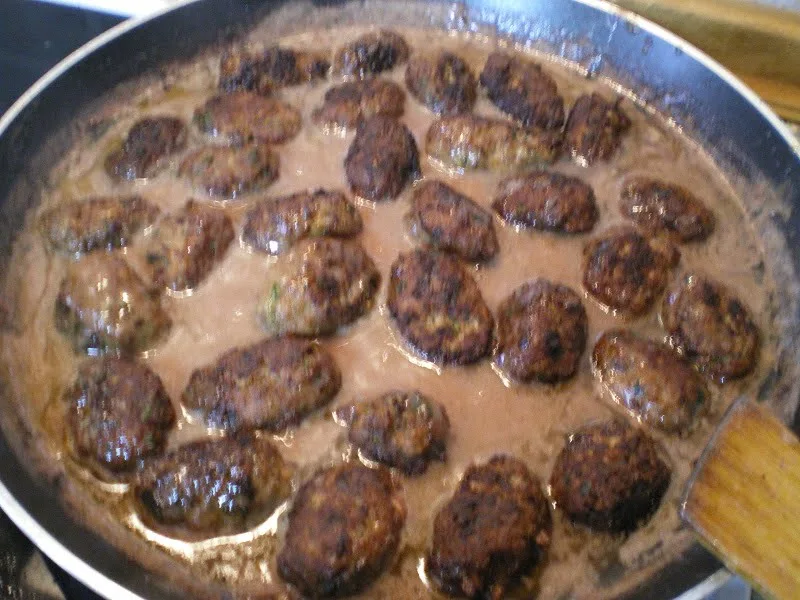 Meatballs cooking in pomegranate sauce image