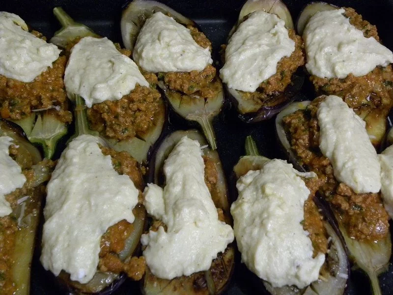 Papoutsakia (stuffed eggplants) with meat sauce and bechamel before baking image