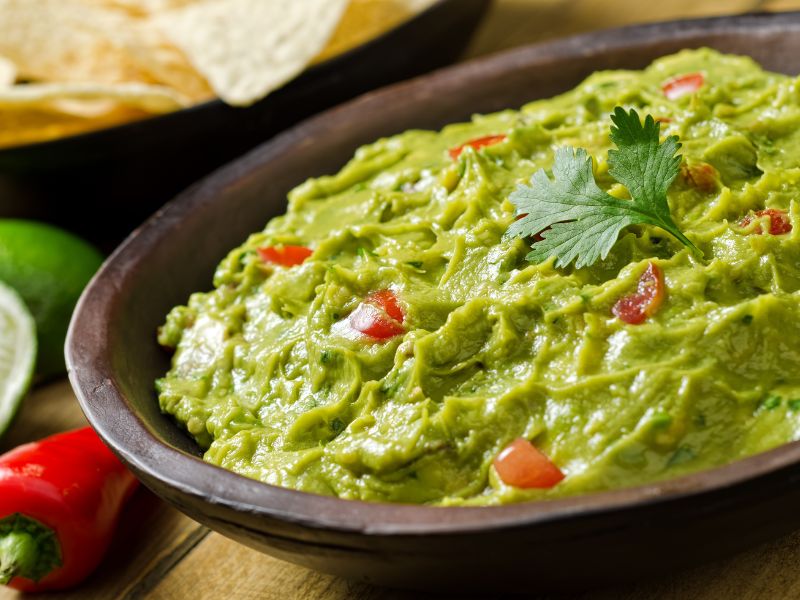 Guacamole with ingredients around it image