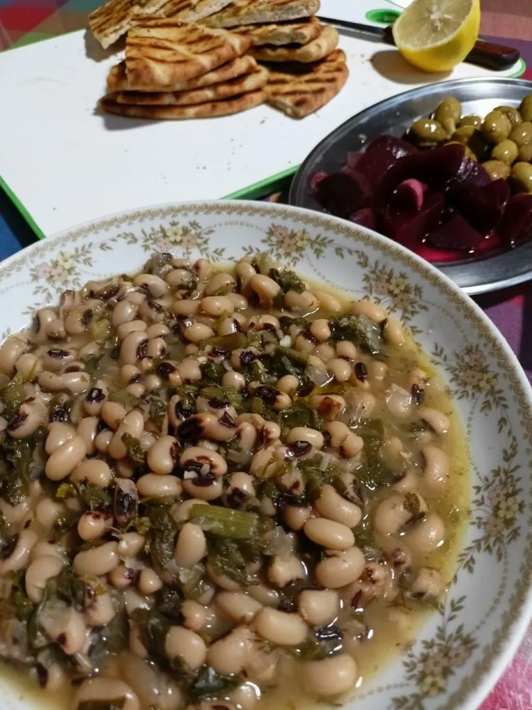 Louvi or mavrommatika served with pickled beets, elies tsakkistes and pita bread image