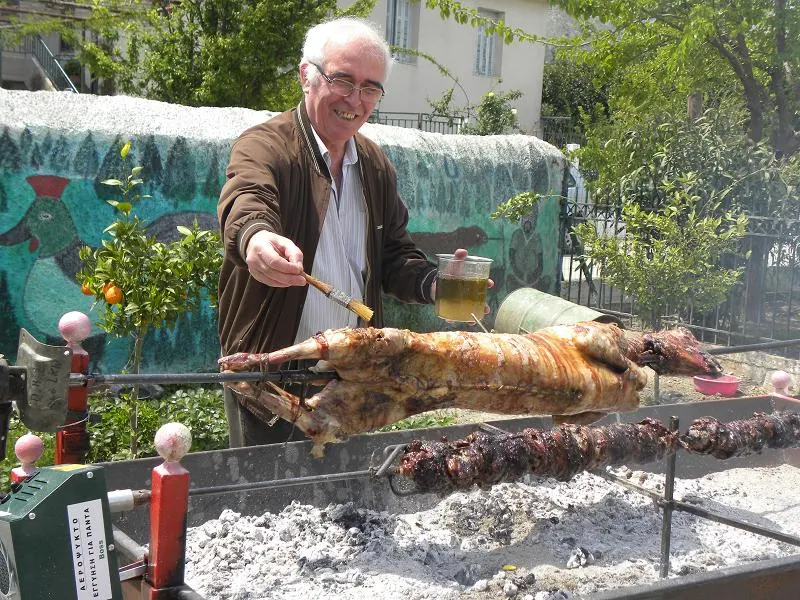 Demetris basting lamb and kokoretsi image