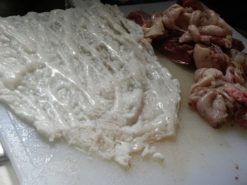 lamb offal being wrapped in caul fat image