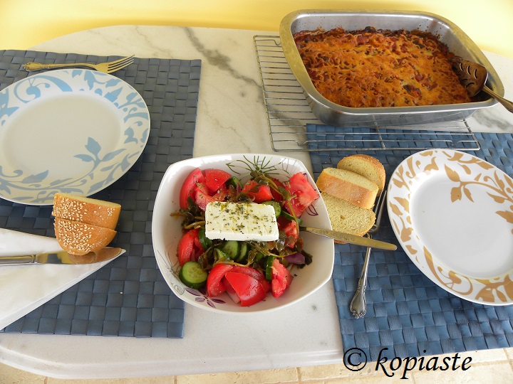 Table with Eggplant casserole and greek salad