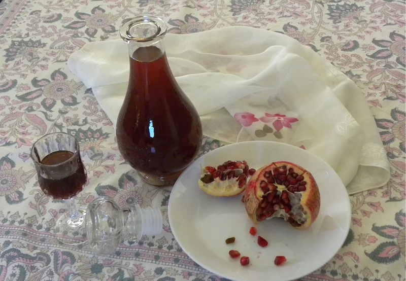 Pomegranate Liqueur in a glass and bottle photo