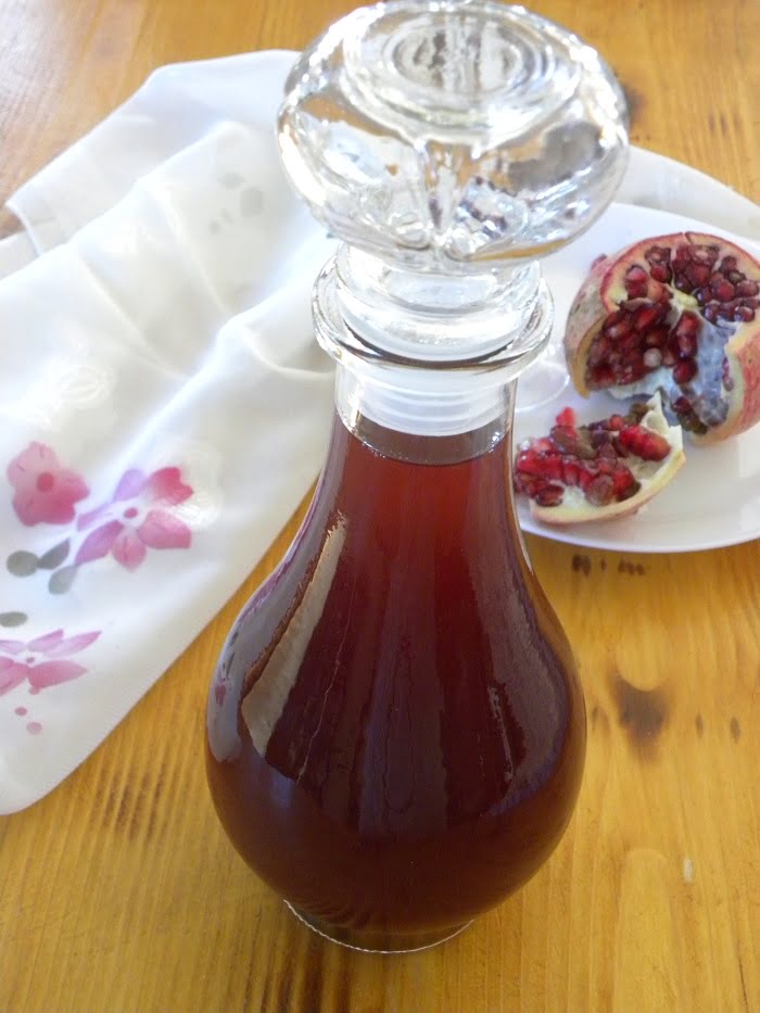 Pomegranate Liqueur in a bottle and open pomegranate fruit image