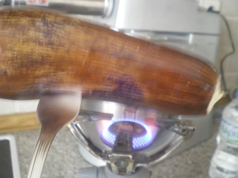 Charring an eggplant over flame image