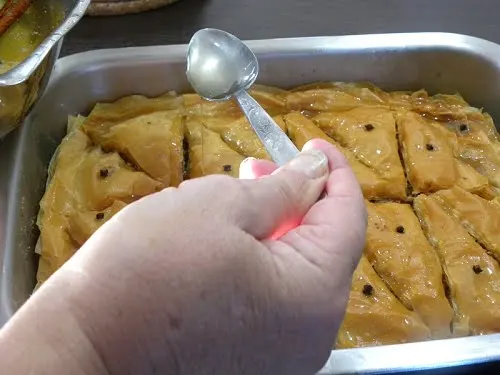 Adding syrup to baklavas image