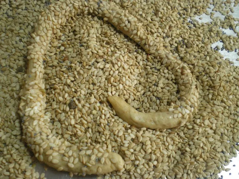 Dipping the dough in water and then coating with sesame seeds image