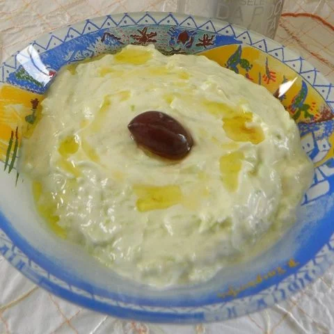 tzatziki in a bowl with an olive in the centre image