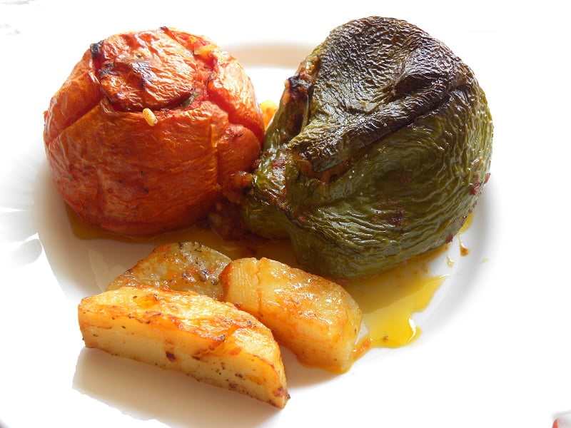 A stuffed tomato and green pepper with potatoes image