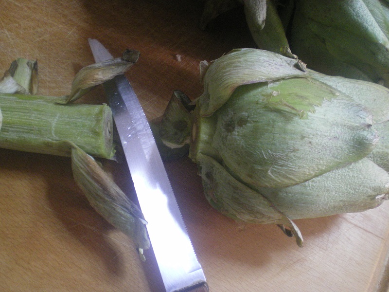 Cutting off the stem of the artichoke image