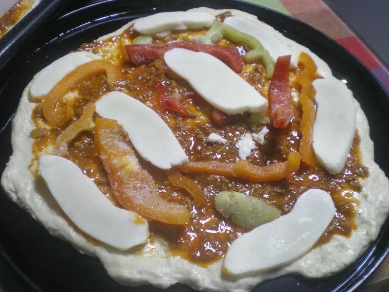 Pizza dough, meat sauce, bell peppers and halloumi pizza image