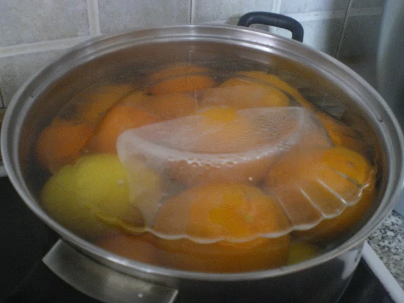 Boiling citrus fruit with a plate on top image