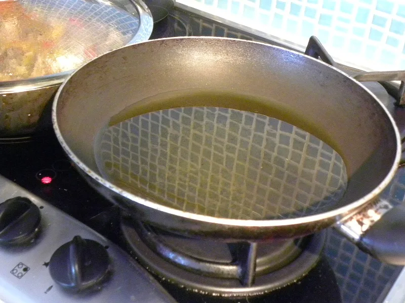 Heating the olive oil in a frying pan image