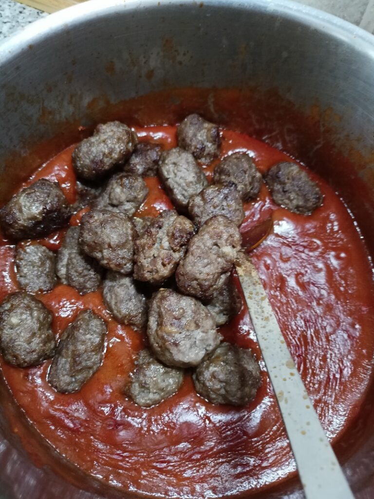 Putting the meatballs in the sauce image