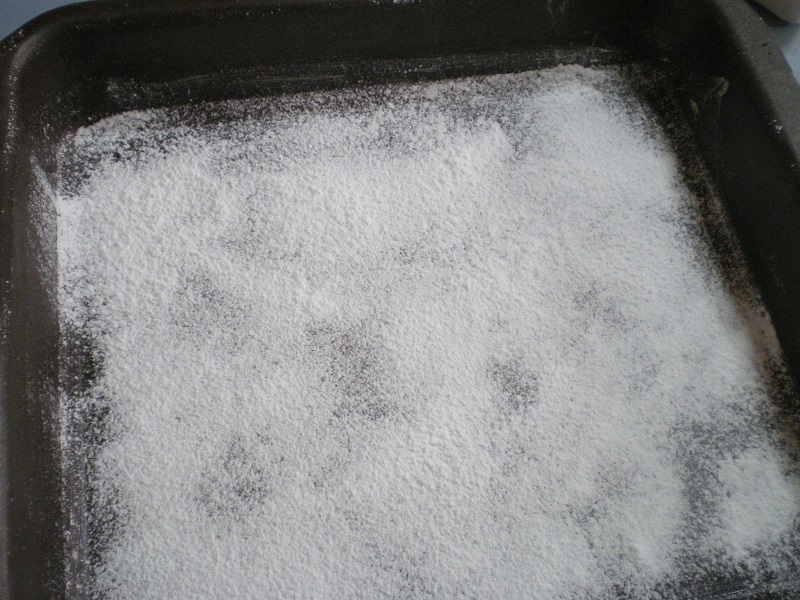 dusting the baking tray with icing sugar and corn flour image