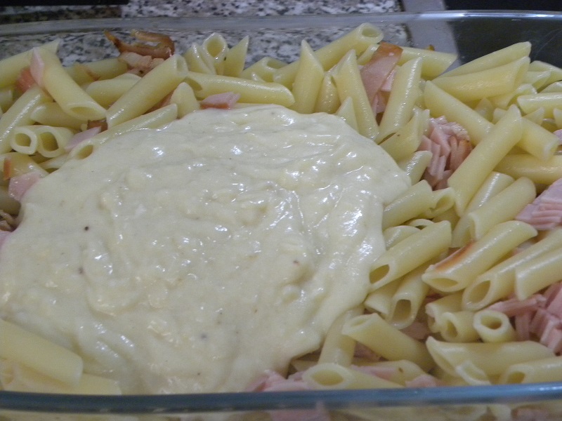 Adding half the bechamel to the pasta image
