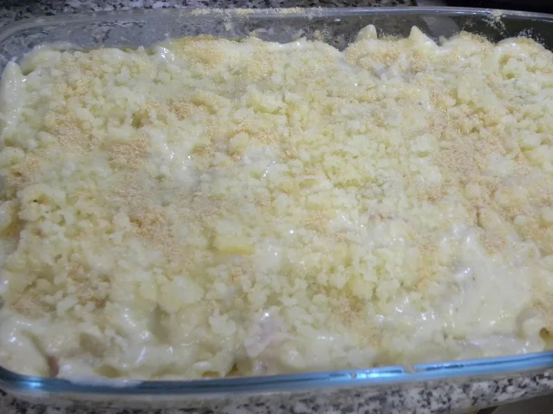 Adding the remaining bechamel and graviera on top image