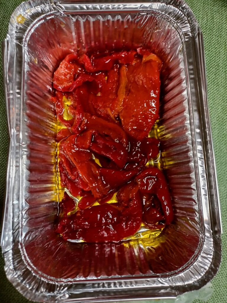 Layer red roasted peppers in an aluminium baking tray image
