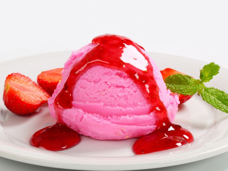 Strawberry coulis on ice cream image