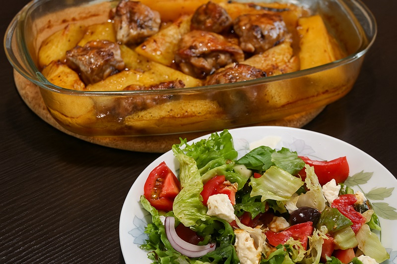 Marinated chicken thighs served with potatoes and a salad image